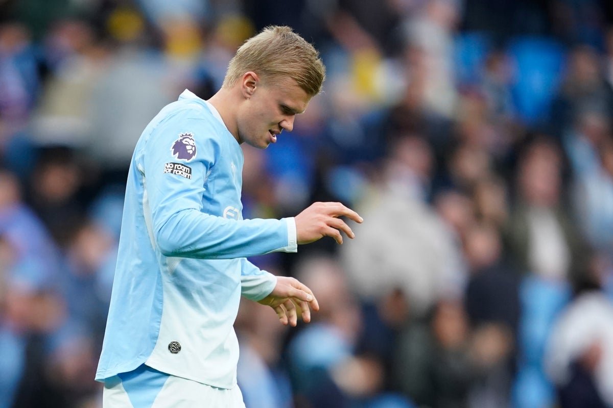 Manchester City's Erling Haaland grimaces on the pitch as he hobbles down the tunnel (AP)